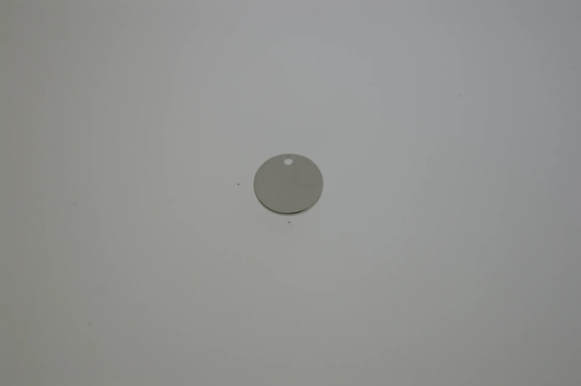 Disque en laiton Ø 10mm avec trou. Finition bronze blanc.