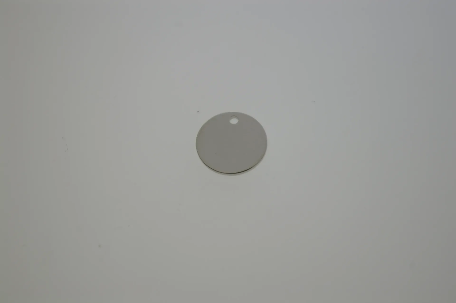 [129571215] Brass disc Ø 12mm with hole. White bronze plated.